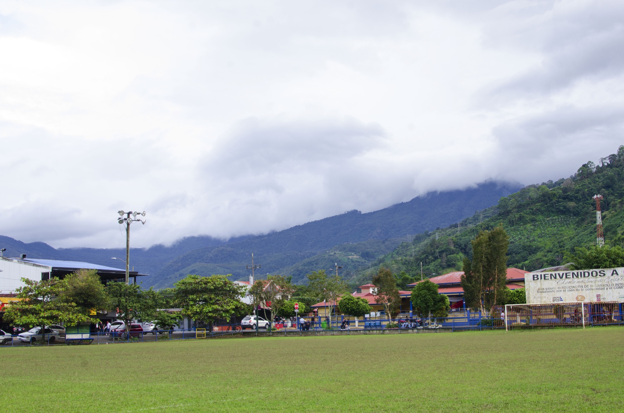 Pueblo de Orosí al pie de montañas cubiertas de nubes